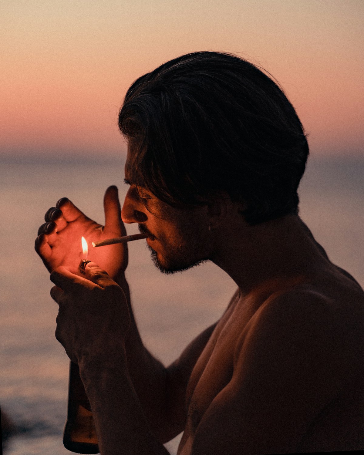 A man lighting a cigarette at sunset — exactly the sort of scene that keeps us up at night
